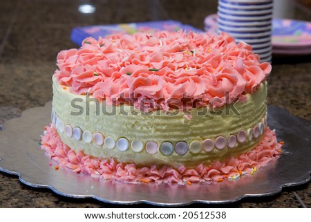 a pink birthday cake closeup on granite counter top