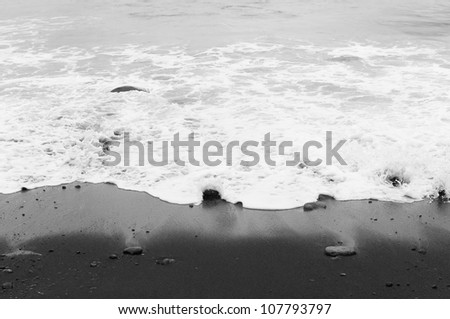 Background with sea wave and black volcanic sand