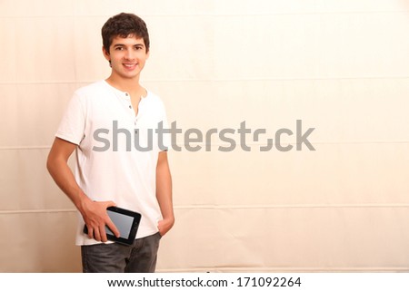 A young, latin man with a Tablet PC, face in focus