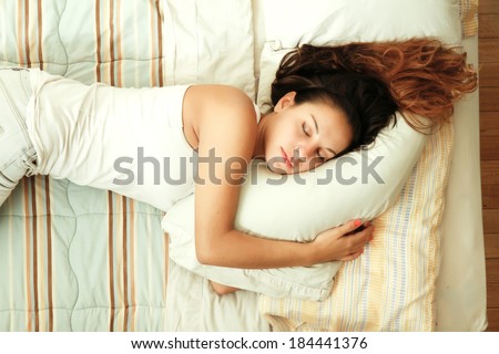 A young woman sleeping on the bed.