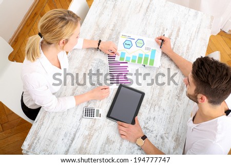 A young couple organizing their financial situation at home.