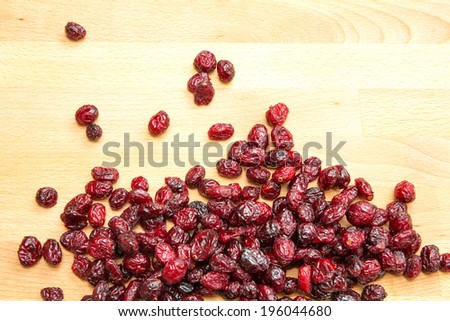 Some dried cranberries on a wooden background.