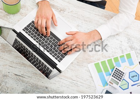 A young man checking his business statistics at home
