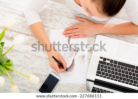 A young fashion designer working with a laptop.