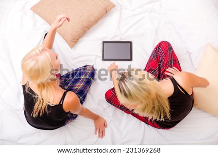 Mother and Daughter enjoying a Pyjama party with a Tablet PC.