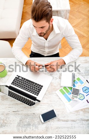 A young man sitting at the table with a laptop computer.