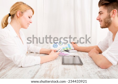A happy young couple organizing their financial situation at home.
