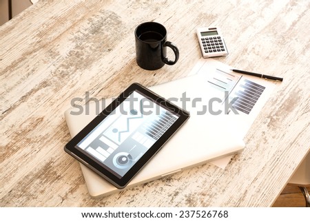 Business Analytics on a wooden Desk with a Tablet PC and a Laptop.