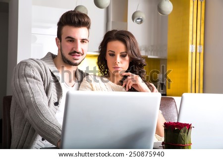 A young couple using in the evening their laptop computers at home.