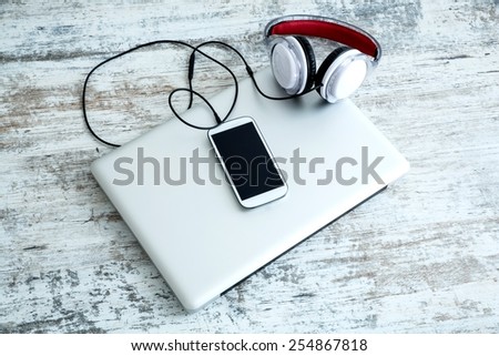 Headphones connected to a smartphone and a Laptop computer.