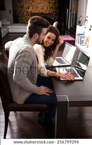 Young couple using a Tablet PC together on the Sofa at home.