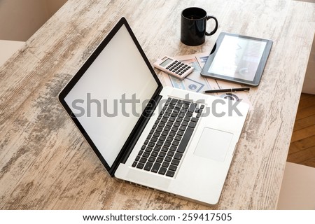 A wooden office Desktop with a Laptop and a Tablet PC.