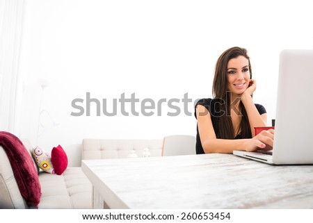 A young beautiful woman using a Laptop computer at home.