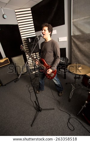A Rock singer playing bass in the rehearsal Studio.