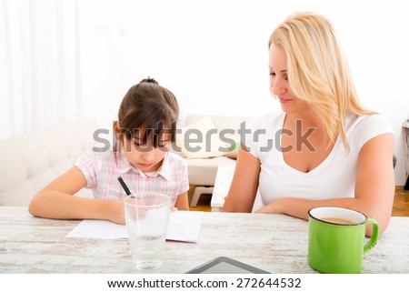 A mother helping her daughter with the homework.
