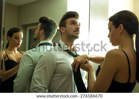 A young couple preparing to go out and getting ready and dressed in the changing room.