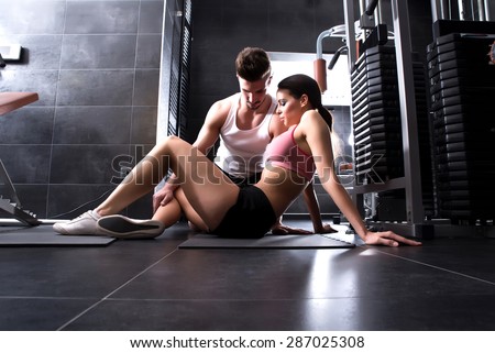 A young man and a young woman working out in the Gym.