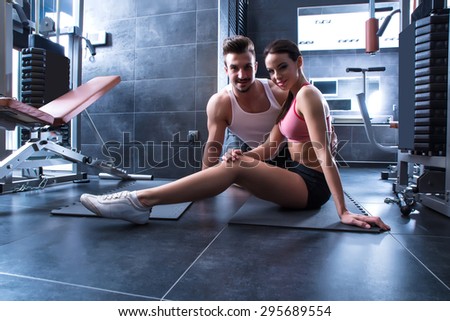 A young man and a young woman working out in the Gym.