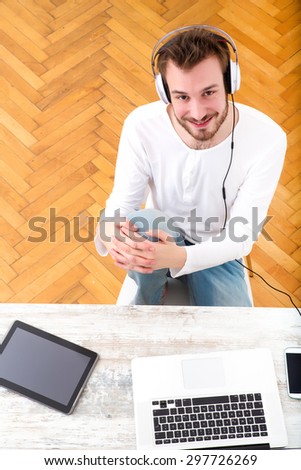 A young man listening to music on his Laptop computer.