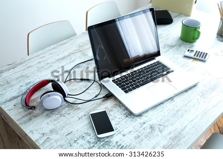 A Laptop in a modern home office setup on a wooden Table.