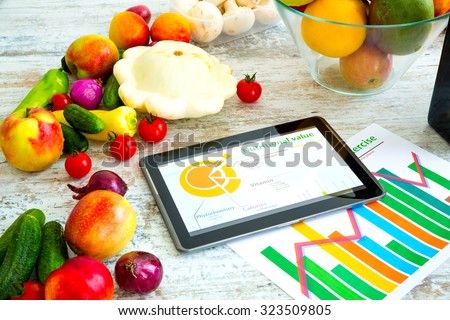 Organic food and a Tablet PC showing information about healthy nutrition and phytochemical composition.