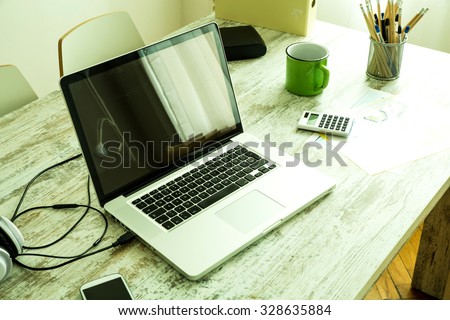 A Laptop in a modern home office setup on a wooden Table.