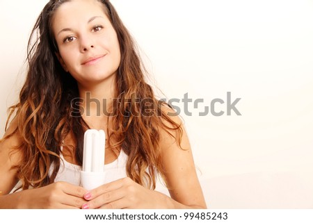Young girl with a energy saver light bulb.