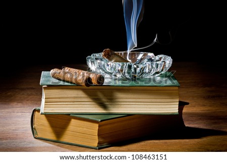 Cigar with ashtray and two books volume
