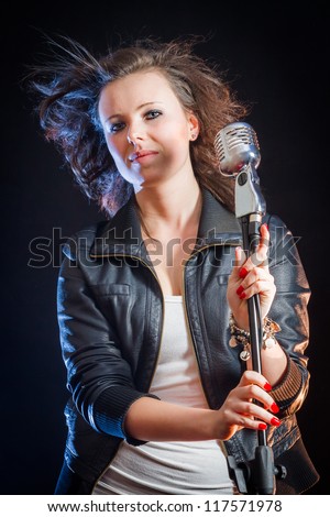 Young singer on the stage with microphone