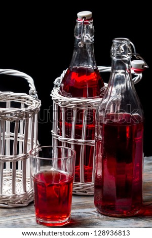 Old bottles in basket with red juice