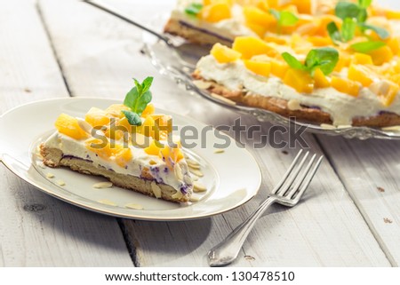 Cake with cream and peaches on a plate