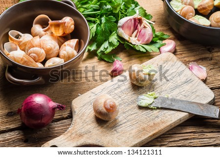Closeup of preparing snails with garlic butter and herbs