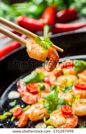 Fried shrimp on chopsticks with herbs