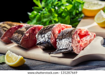 Fresh fish with lemon and salt on cutting board