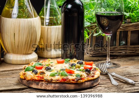 Homemade baked pizza served with wine