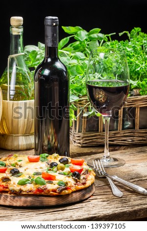 Freshly baked pizza served with red wine