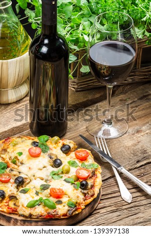 Freshly baked pizza served with wine