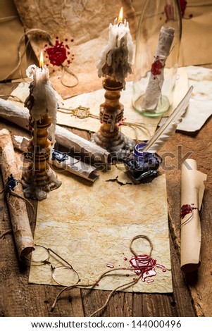 Vintage scrolls and candles are the old scribe\'s workplace