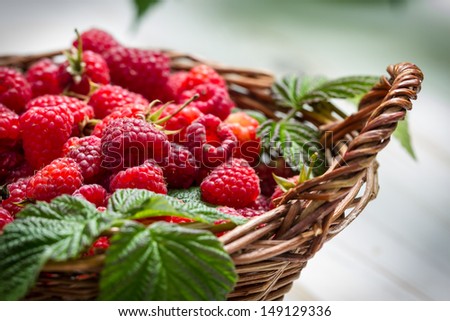 Fresh raspberries in a small wicker basket