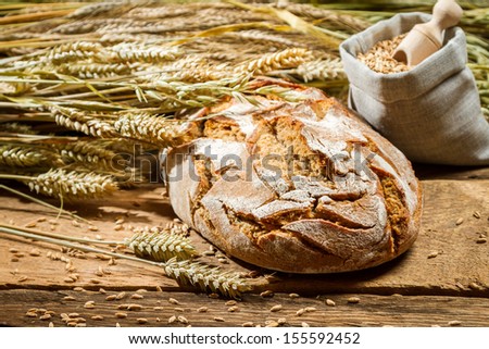 Freshly baked loaf of bread and a bag with grains