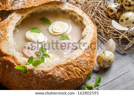 Closeup of soup served in bread with sausage and egg