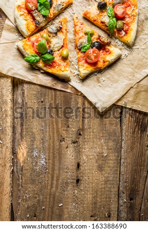 Fresh pizza on paper and old wooden table as background 8