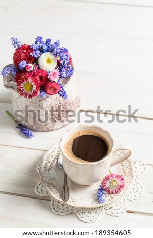 Spring flowers and coffee on old table