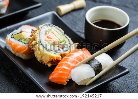 Sushi with soy sauce eaten with chopsticks