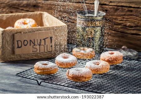 Icing sugar falling on fresh donuts