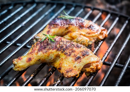 Roasted chicken legs on the grill with fire