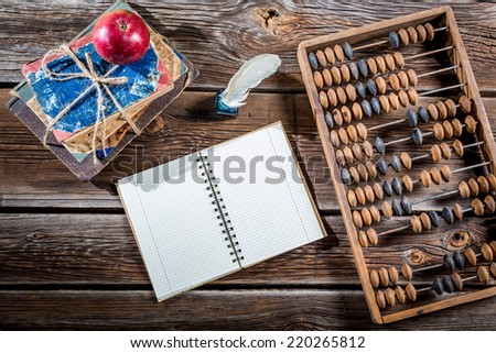 Old abacus, pen and books on mathematics classes