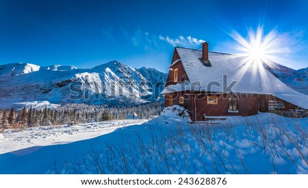 Mountain small cottage in a winter dawn