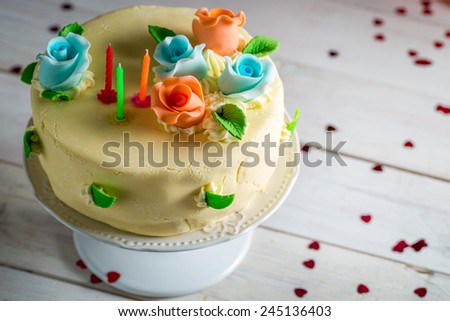Birthday cake with candles and sugar roses