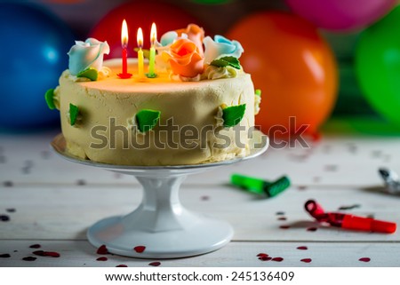 Balloons and birthday cake with candles for a party